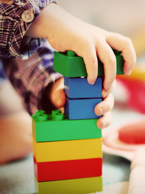 child stacking lego blocks